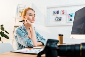 Pensive young retoucher using desktop computer and 2022 12 16 16 28 13 utc