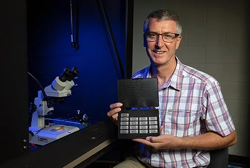 Paul Thibado, professor of physics, with sample energy-harvesting chips under development. (CREDIT: University of Arkansas)
