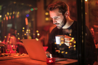 Man Holding Mug in Front of Laptop Free Stock Photo