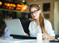 woman working on laptop with cup of coffee