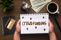 Notepad with crowdfunding concept in woman hands WJCZ84D