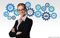 Woman standing in front of gears represnting building blocks.