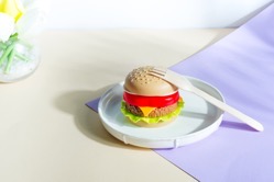 Plastic hamburger on a plate with wooden fork din 2021 08 29 03 28 50 utc