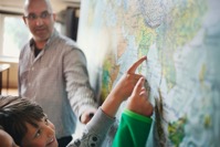 Professor looking at students pointing at map MPLXS64