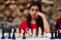 Woman looking at a chess set.