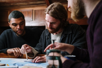 people working together on a drawing on a table.