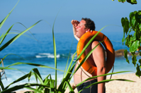Man sweathing on beach in the summer heat.