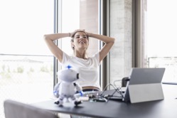 Smiling young woman sitting at desk in office havi 2022 03 08 01 32 42 utc