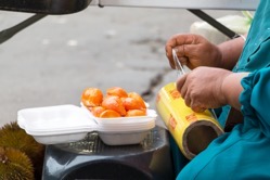 Street vendor packing a durian in a biodegradable 2021 10 23 22 28 17 utc