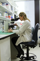Biotech - Technician looking into a microscope.