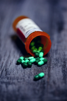 pill bottle with pills spilling out on a table.
