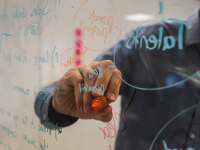 person writing on glass with a grease marker