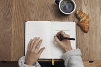 person writing in their organizer
