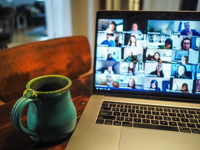 laptop with coffee mug next to it.