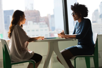 job interview - Two women sitting at a table talking.