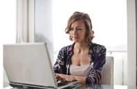 Woman in Blue Floral Top Sitting While Using Laptop Free Stock Photo
