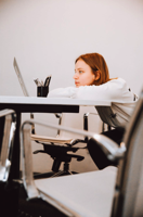 Woman in White Long Sleeve Shirt Sitting on Black Chair Free Stock Photo