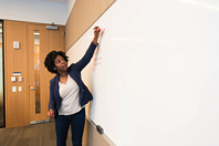 Woman Writing on Dry erase Board Free Stock Photo