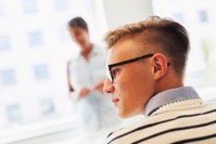 Young man wearing glasses with professor in backgr 3Y3EQ9V