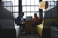 Bonnie Alfonso, left, President and Chief Embellishment Officer at Alfie Logo Gear for Work and Play, looks on as Yan Ness, right, CEO of Online Tech Inc., talks about the state’s economic gardening program at an event March 20 at the Pantlind Ballroom. 